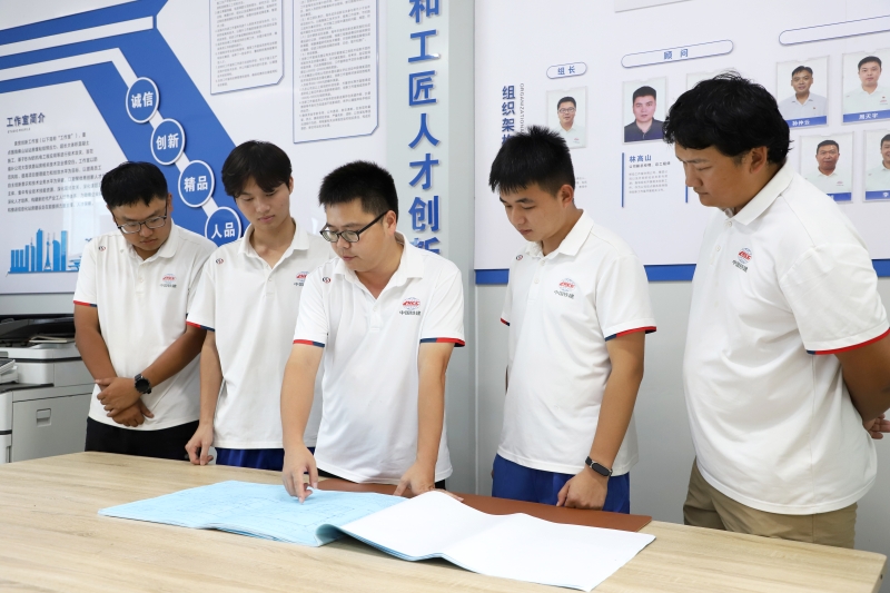 3圖為袁寬與技術(shù)人員探討施工方案(李佳珊 攝).jpg